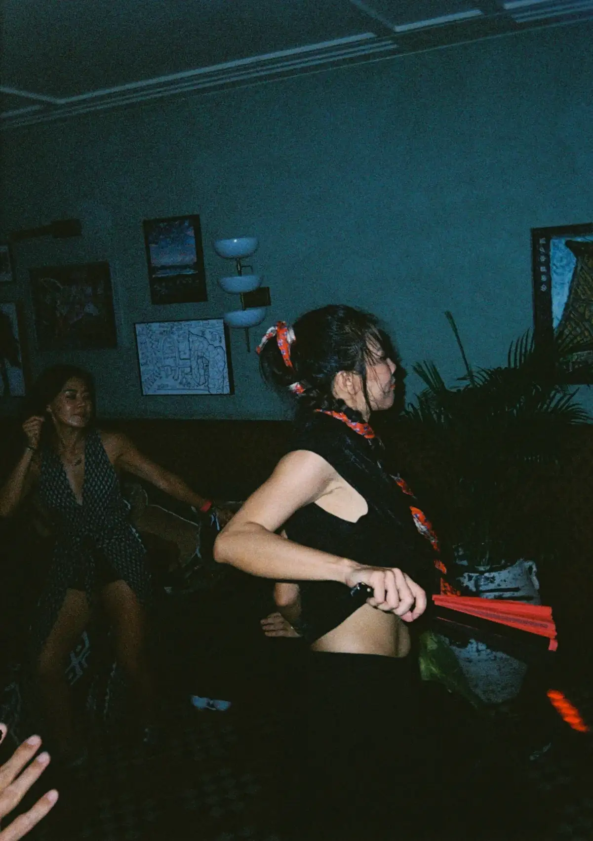 A woman grooving to music with a fan in her hand